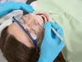 Dentysta leczy ząb u ciężarnej kobiety. Szukasz co na ból zęba w ciąży? Konsultacja ze stomatologiem jest kluczowa.