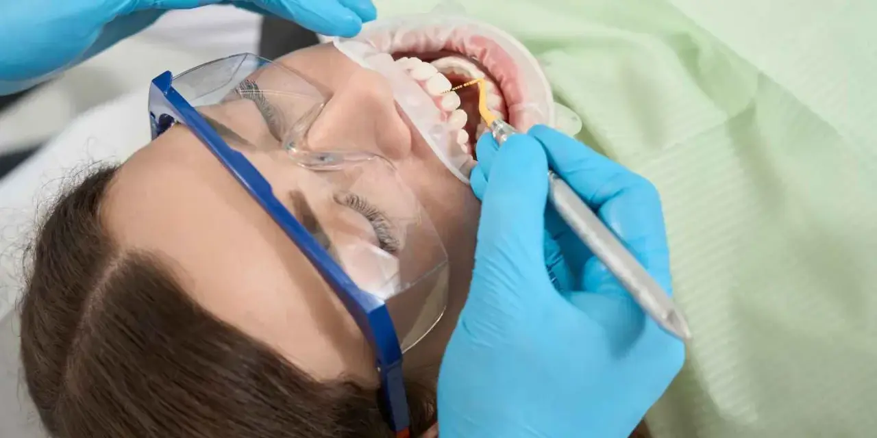 Dentysta leczy ząb u ciężarnej kobiety. Szukasz co na ból zęba w ciąży? Konsultacja ze stomatologiem jest kluczowa.