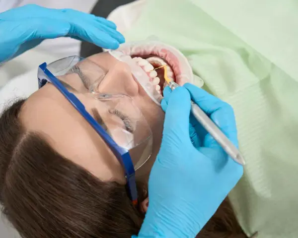 Dentysta leczy ząb u ciężarnej kobiety. Szukasz co na ból zęba w ciąży? Konsultacja ze stomatologiem jest kluczowa.