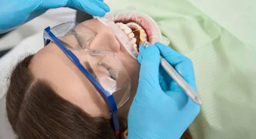 Dentysta leczy ząb u ciężarnej kobiety. Szukasz co na ból zęba w ciąży? Konsultacja ze stomatologiem jest kluczowa.